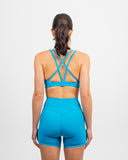 Back view of the Azure Blue Nexletica Synergy Sports Bra showing the strappy crossed back and tonal NEXLETICA underbust band