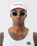 Front-on view of the white Nexletica Perform Hat worn with sunglasses, showing the NEXLETICA branding