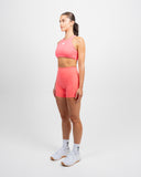 Close up of coral Impulse High Neck Sports Bra fabric showing buttery soft finish and smooth seams”