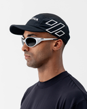 Man wearing the black Nexletica Perform Hat, front view, showing the white NEXLETICA front print and curved brim