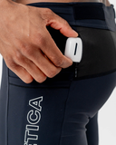 Side detail of the black Nexletica Men's Perform Running Tights with an energy gel in the drop-in pocket