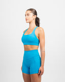Side view of the Azure Blue Nexletica Synergy Sports Bra showing the supportive strap and medium-support fit