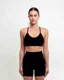 Front view of model wearing Nexletica Synergy Sports Bra in jet black.