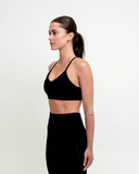 Side profile showing fit and straps of the Synergy Sports Bra jet black 