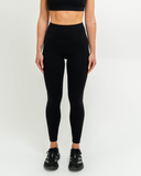 Front view of model wearing Nexletica Synergy Leggings in black