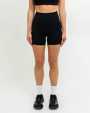 Front view of model wearing Nexletica Synergy Shorts in black