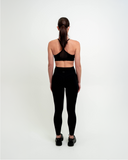 Front view of model wearing Nexletica Synergy Sports Bra in black 